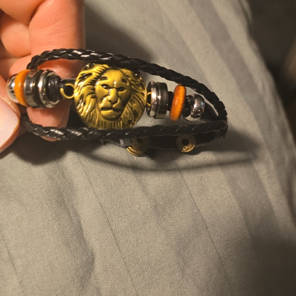 Elegant Black and Gold Lion Faced Charm on Leatherlike Bracelet
